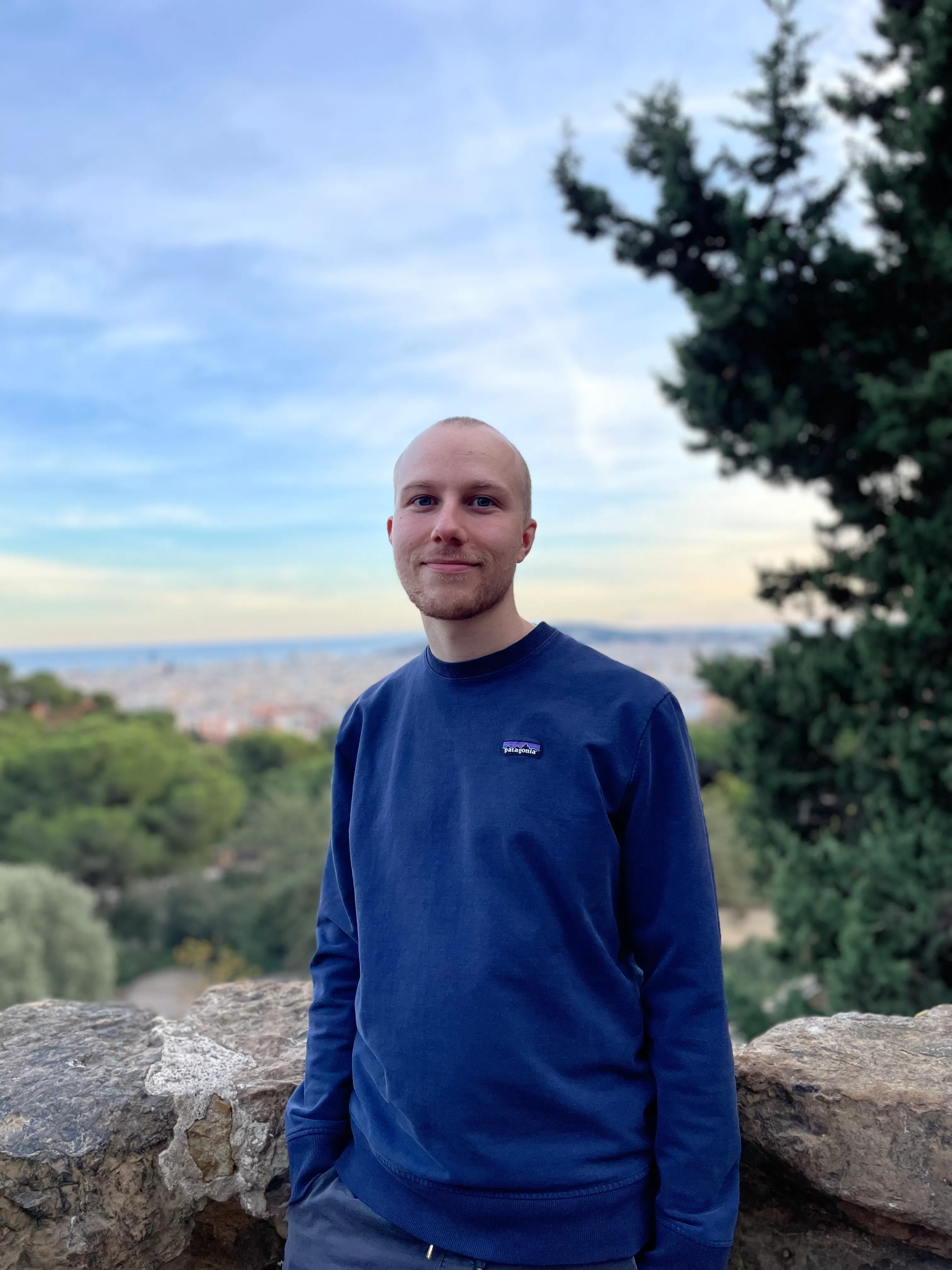 Photo of Ondřej Zajíc with tree and city scenery in the background.
